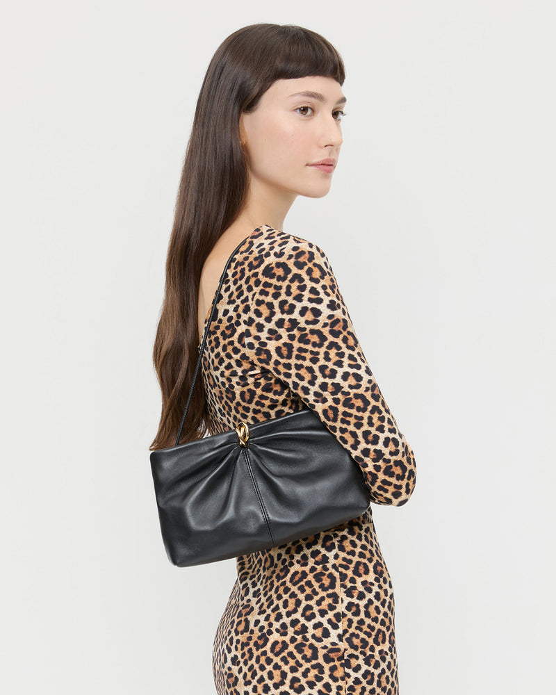 Corrine Black Leather Gathered Clutch in black leather with a gold accent and Inaya Dress in leopard jersey.