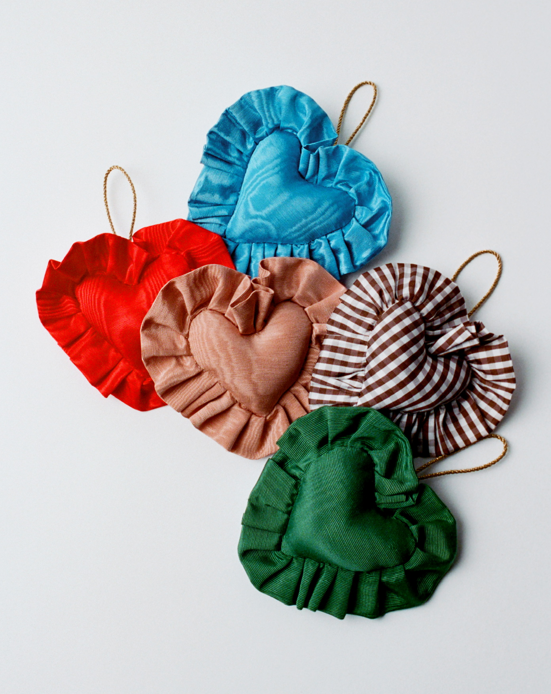 An assortment of heart shaped ornaments in different colors on a grey background.