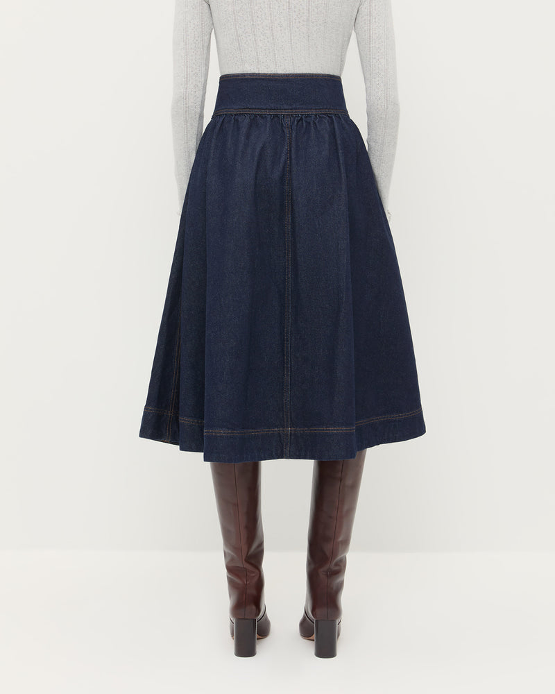 Ruthie Denim Skirt in dark blue denim, Lolo Pointelle Long-Sleeve Top in grey cotton, and Goldy Espresso Leather Tall Boot.