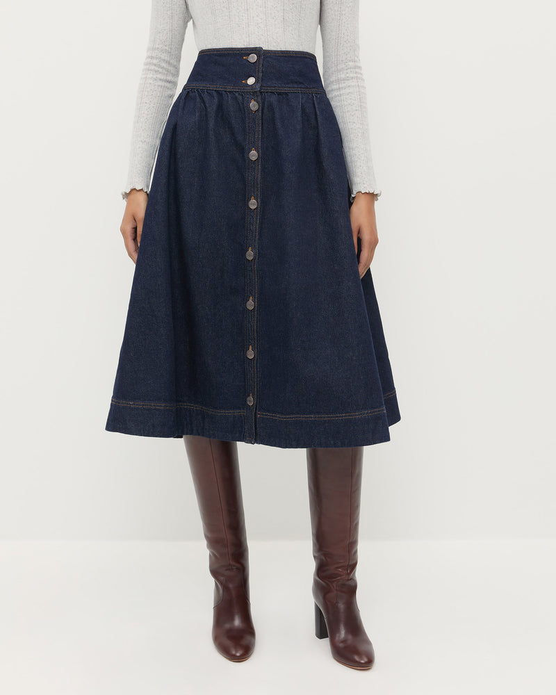 Ruthie Denim Skirt in dark blue denim, Lolo Pointelle Long-Sleeve Top in grey cotton, and Goldy Espresso Leather Tall Boot.
