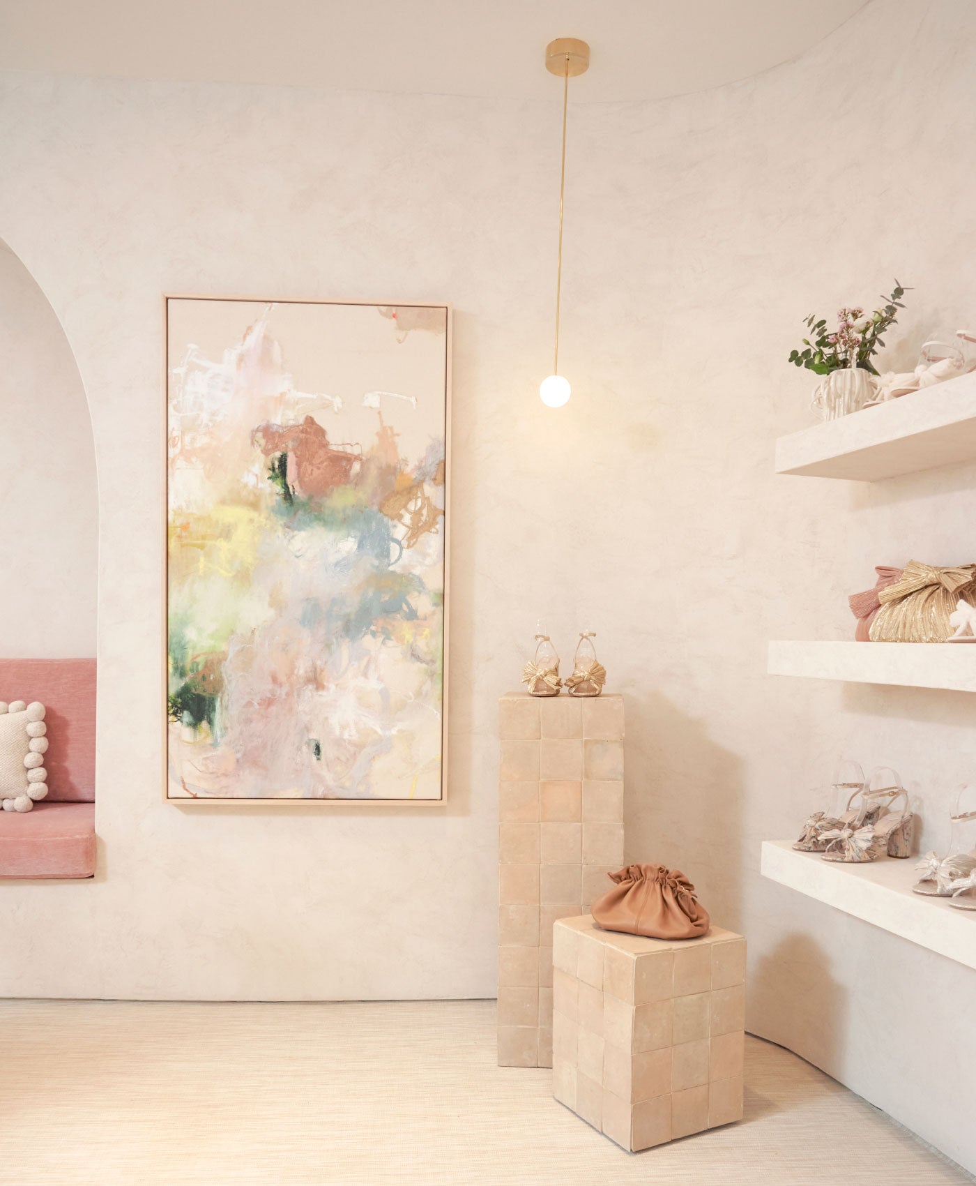 A picture of the corner of the Soho store with shoes and handbags displayed.