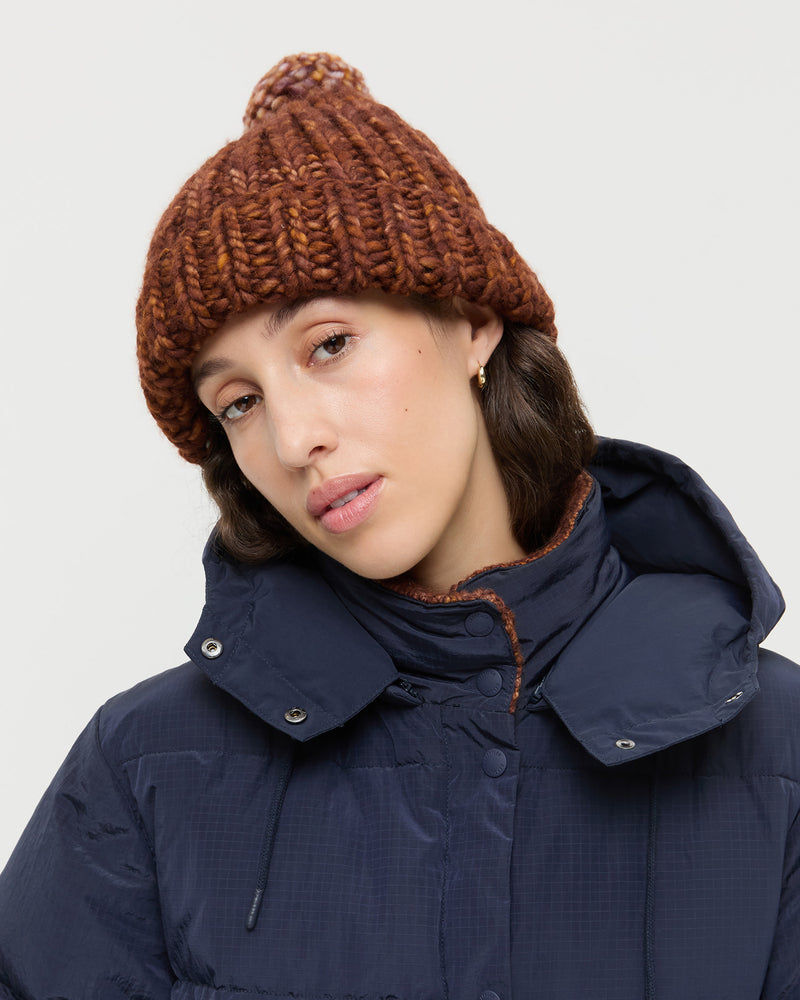 Ava Sienna Knit Pompom Hat in sienna brown wool and Pippa Puffer Coat in navy and sienna brown wool.