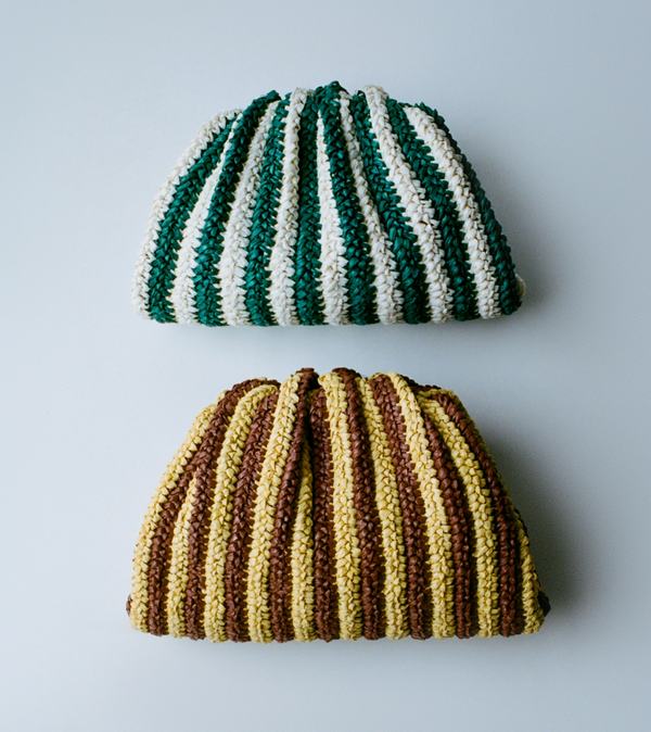 Two striped clutches one in green and white and one in brown and yellow on a grey background.