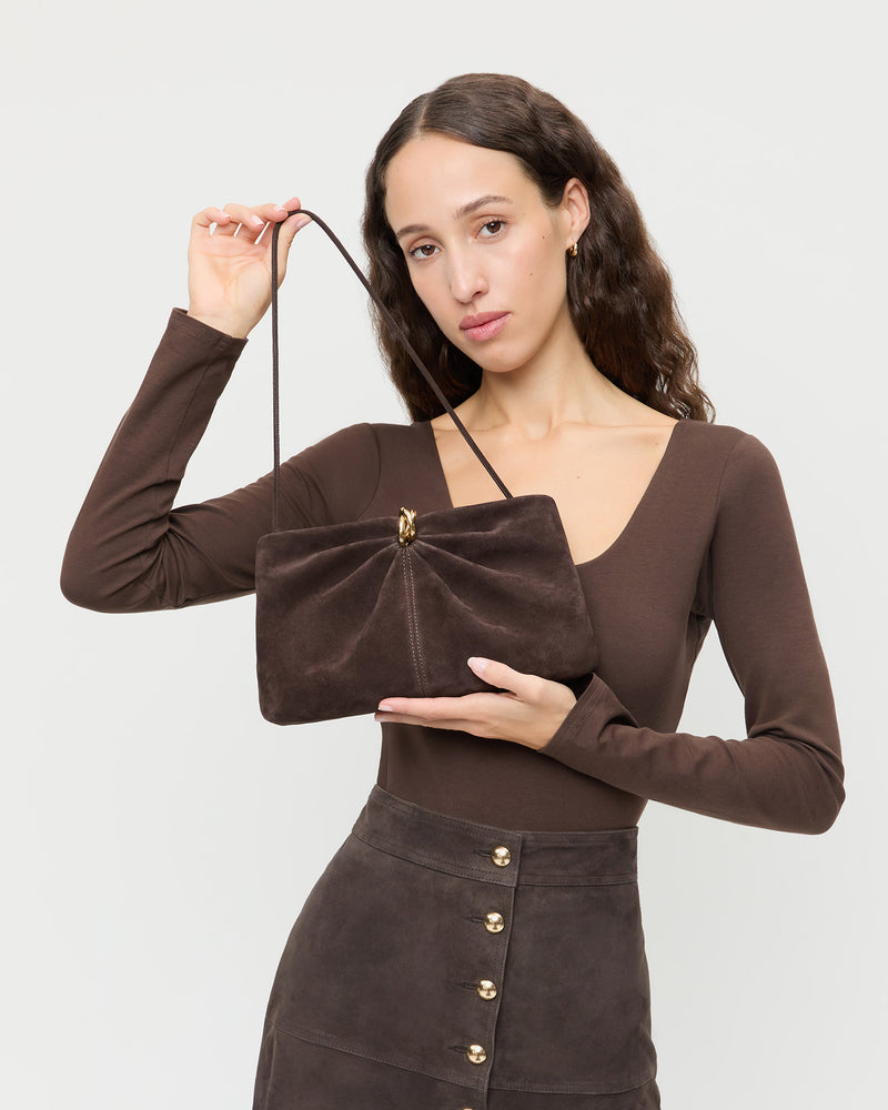 Corrine Brown Suede Gathered Clutch in brown suede with a gold accent, Lumi Long-Sleeve Bodysuit in brown jersey, and Tansy Suede Skirt in brown suede.
