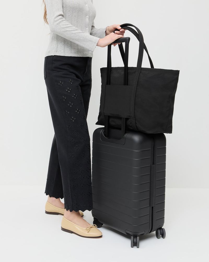 Dina Black Travel Tote in black nylon, Lolo Pointelle Long-Sleeve Top in grey cotton, Demi Embroidered Pant in black denim, and Noelle Bisque Ballet Flat. 