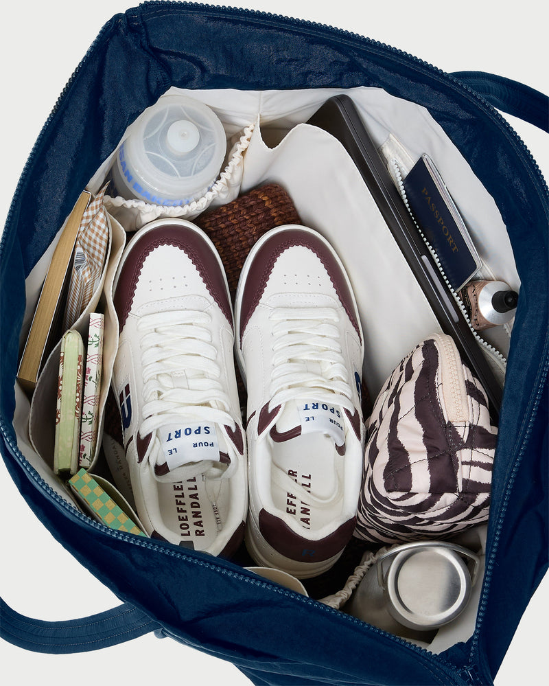 Dina Navy Travel Tote in navy nylon, Topspin Cream/Maroon Court Sneaker, and Georgette Zebra Mini Cosmetic Pouch.