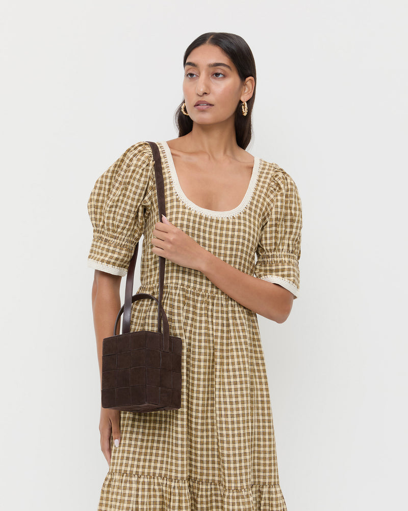 Laith Brown Suede Bucket Bag in brown woven suede and Gillian Puff Sleeve Dress in brown plaid.