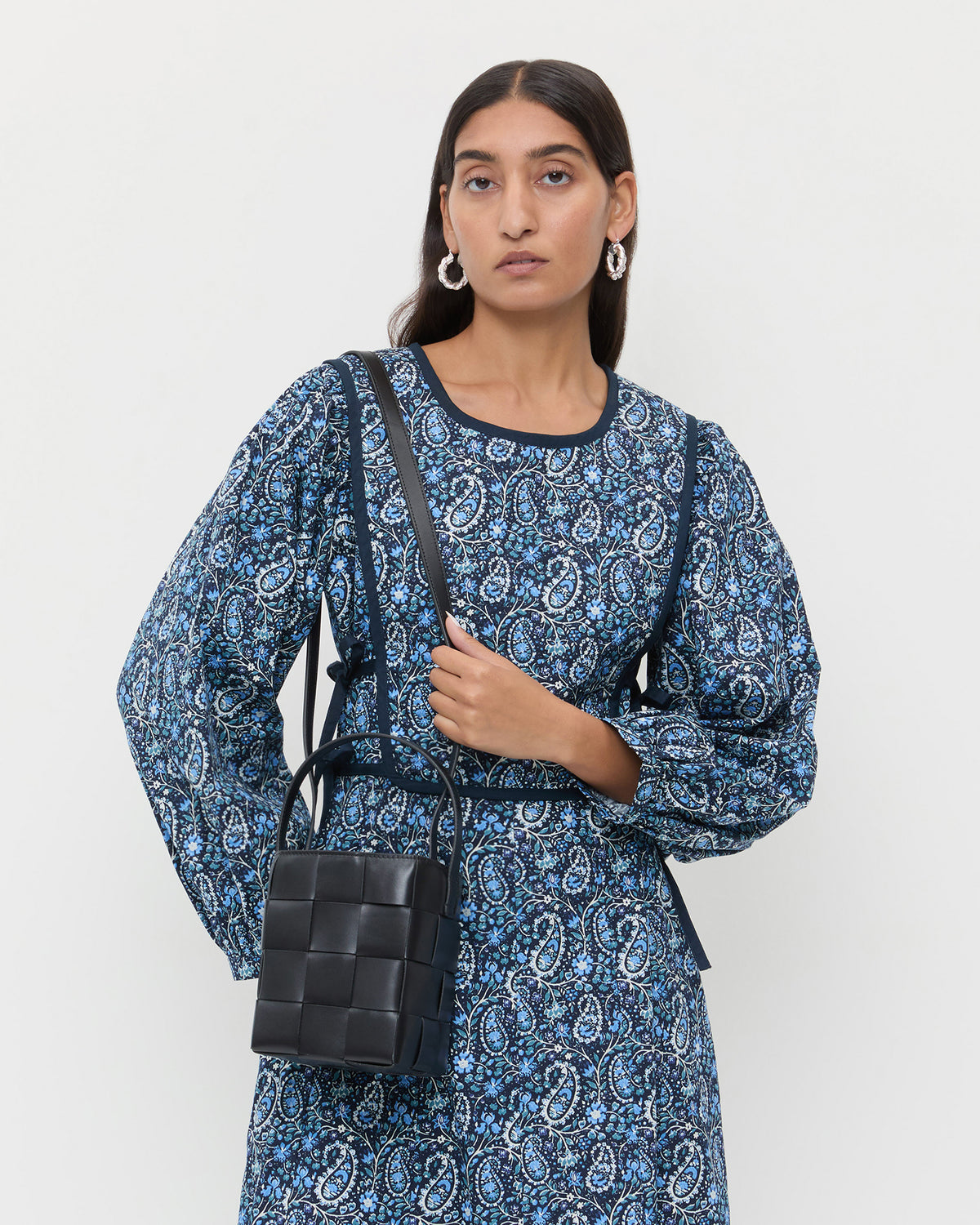 Laith Black Leather Bucket Bag in black woven leather and Ainsley Dress in blue floral.