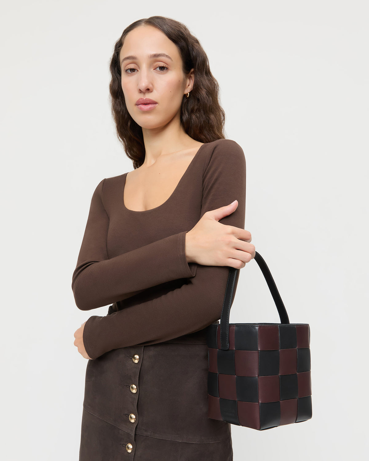 Laith Black/Brown Woven Bucket Bag in brown and black woven leather, Lumi Long-Sleeve Bodysuit in brown jersey fabric.