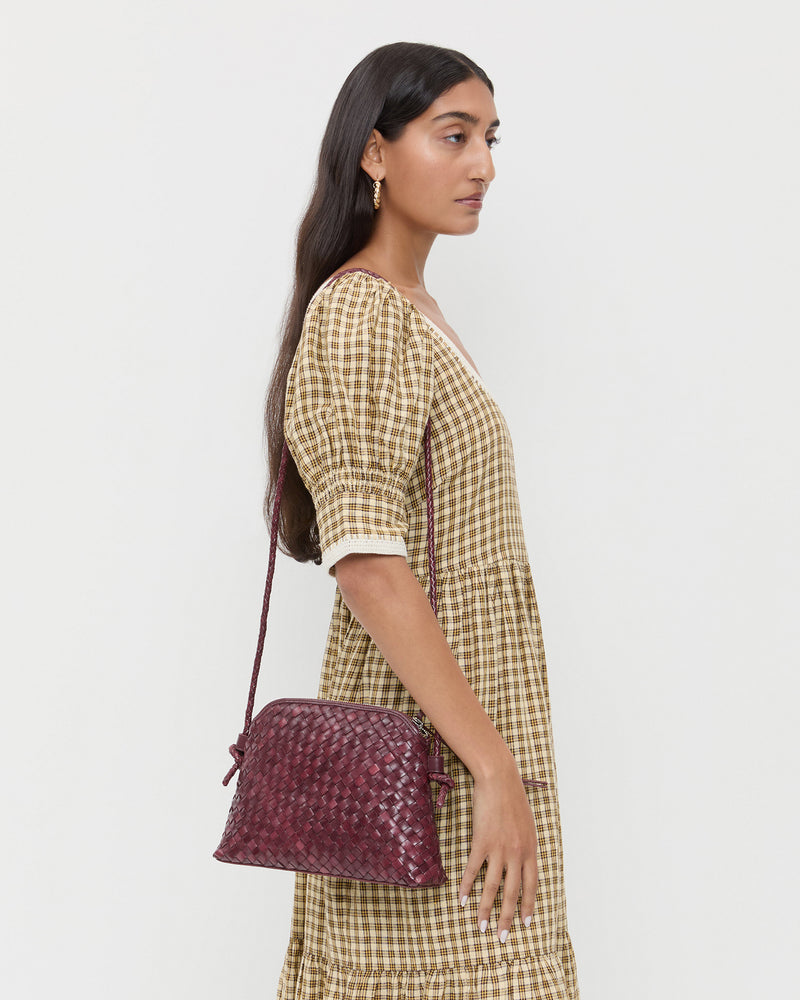 Mallory Maroon Woven Leather Crossbody in maroon woven leather and Gillian Puff Sleeve Dress in brown plaid.