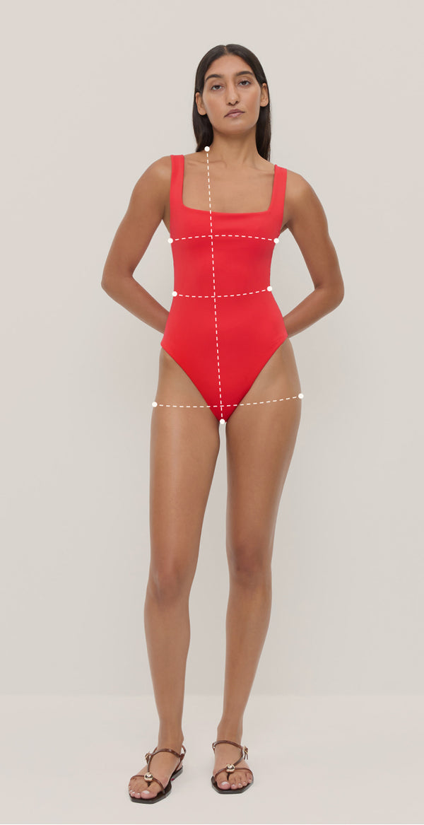 A measurement guide of a model wearing a red one-piece swimsuit. There are lines for measurement across her chest, waist, hips, and from the top of the shoulder to the hip line.