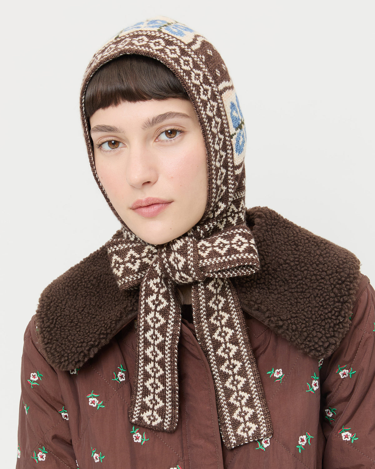 Ophelia Brown/Floral Intarsia Bonnet in brown and blue intarsia knit wool and Wyatt Quilted Coat in brown nylon.