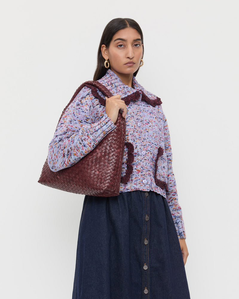 Willow Maroon Woven Hobo Bag in maroon woven leather, Lo Cardigan in marble maroon wool, and Ruthie Denim Skirt in dark blue.