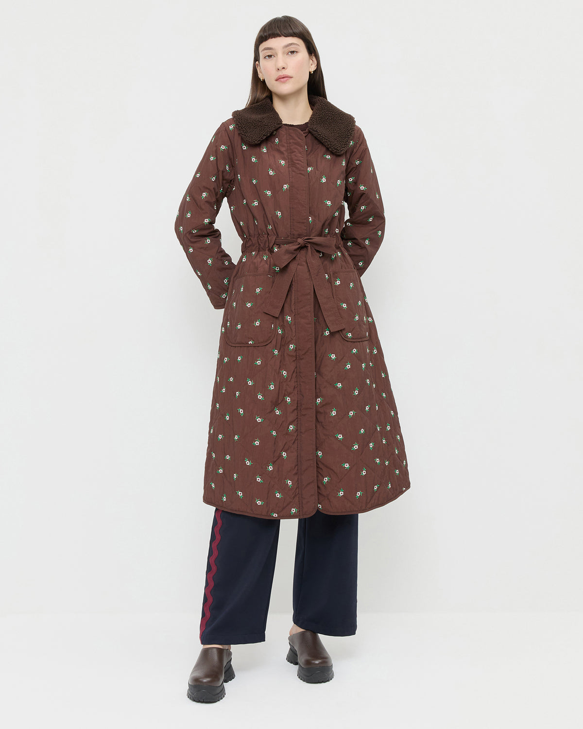 Wyatt Quilted Coat in brown nylon with flower embroidery, Venus Track Pant in navy nylon, and Gemma Brown Leather Lug Mule.