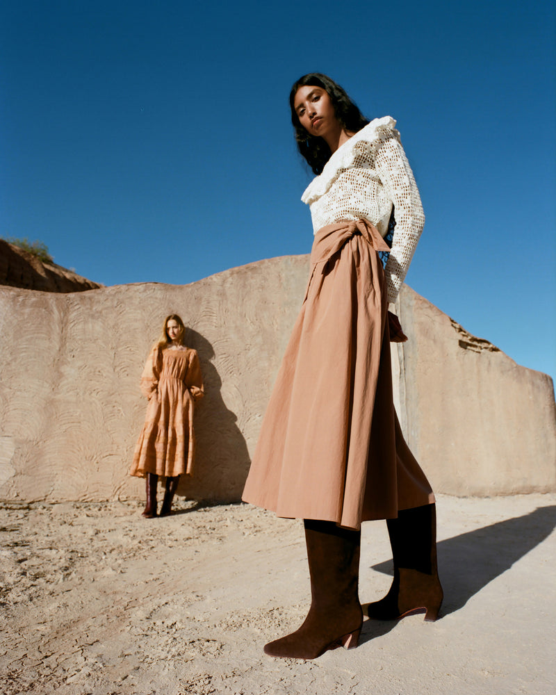 Cleo Brown Suede Mid-Calf Boot in brown suede, Abigail Top in cream crocheted cotton, and Peyton Skirt in light brown cotton.