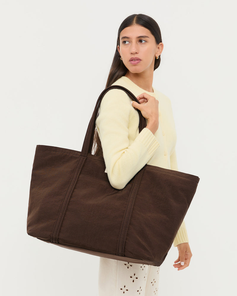 Dina Chocolate Travel Tote in chocolate brown water-resistant nylon, Tucker Cardigan in butter cashmere, and Demi Embroidered Pant in natural cotton.