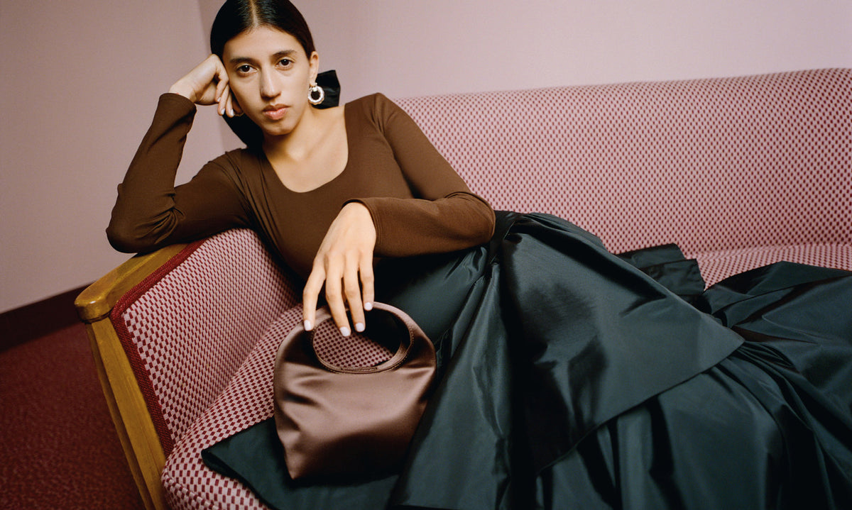 Lumi Long-Sleeve Bodysuit in chocolate brown jersey fabric, Sora Skirt in black taffeta, and Kenzie Chocolate Satin Mini Bag - Loeffler Randall