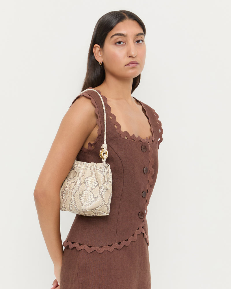 Kiri Snake Leather Shoulder Bag with gold hardware, Teagan Top in brown linen, and TCarissa Bottom in brown linen.